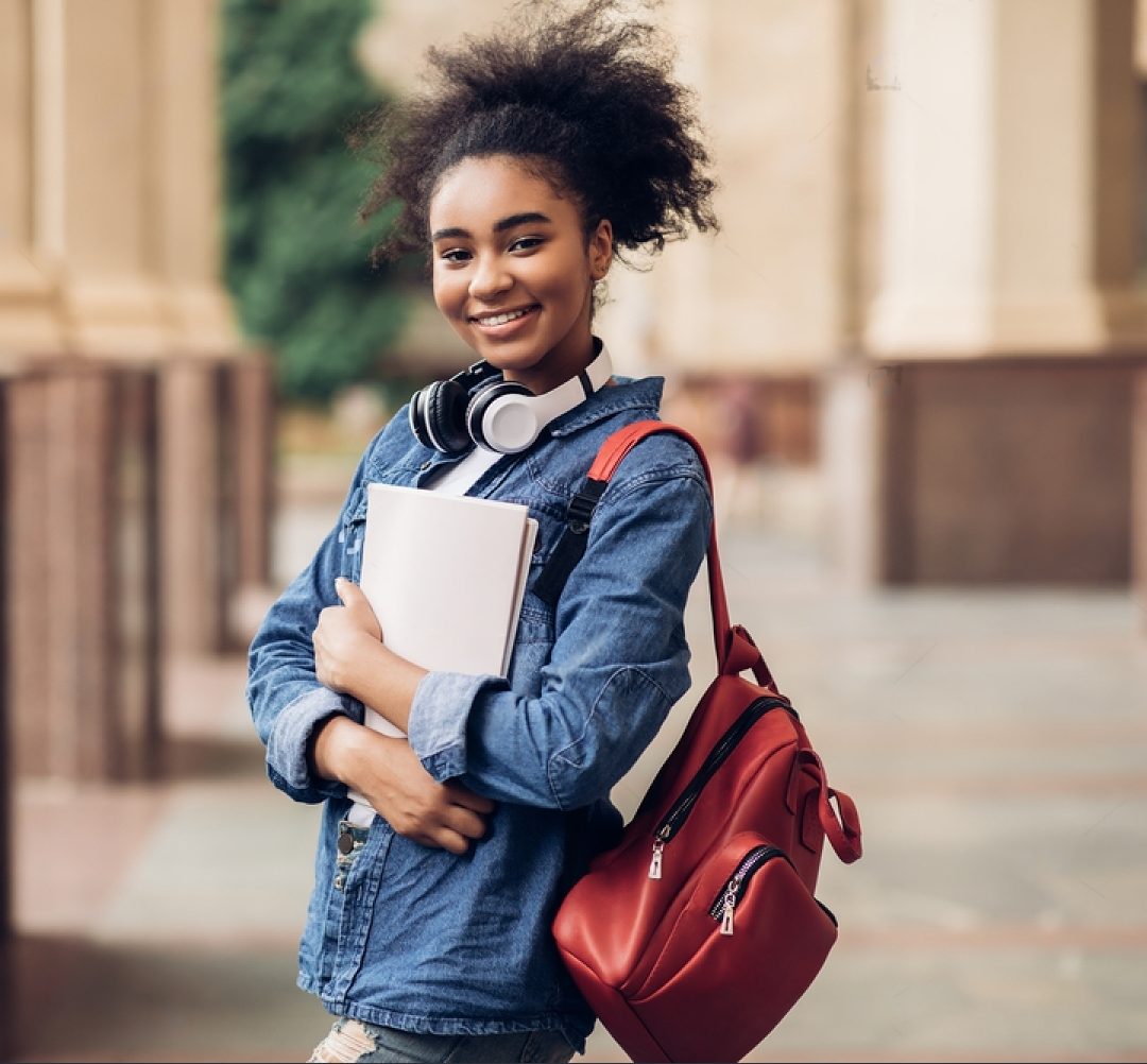 Stock Photo Cheerful Black Student Girl Hugging Books Posing With Backpack Near College Building Outdoor 2026823639 Transformed E1718881466315